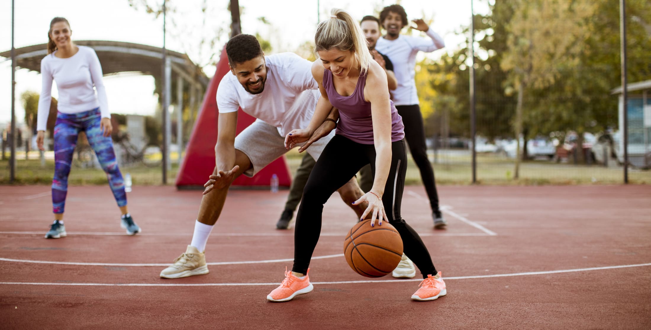 Friends playing basketball on an outdoor court