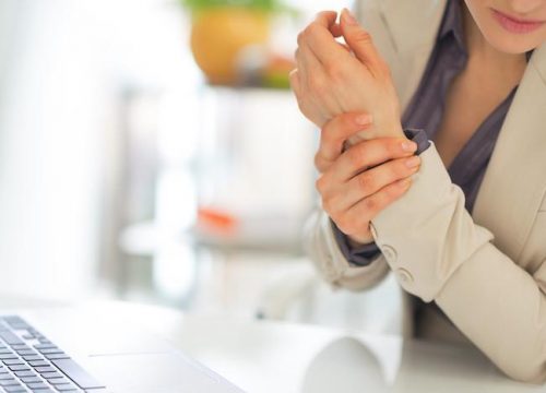 Woman dealing with arthritis at the office