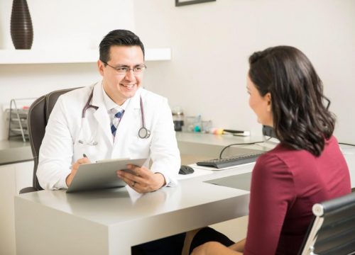 Male doctor speaking with a female patient in his office