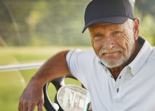 Happy older man sitting in a golf cart