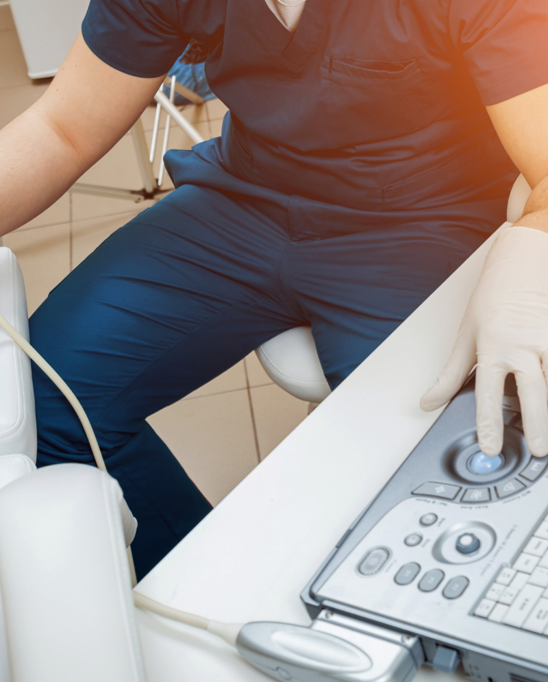 nurse in scrubs sitting in front of a desk.