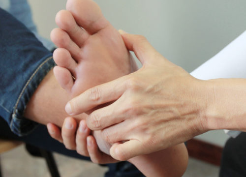 Woman checking a patient's foot